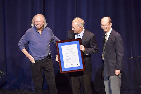 Singer-songwriter-producer Barry Gibb, left, laughs at an audience member's comment Monday night at MTSU during his recognition as the inaugural fellow of The Center for Popular Music in the university's College of Mass Communication. Presenting Gibb with documentation of his honor inside Tucker Theatre are mass comm Dean Ken Paulson, center, and Dr. Dale Cockrell, director of the center. (MTSU photo by Andy Heidt)