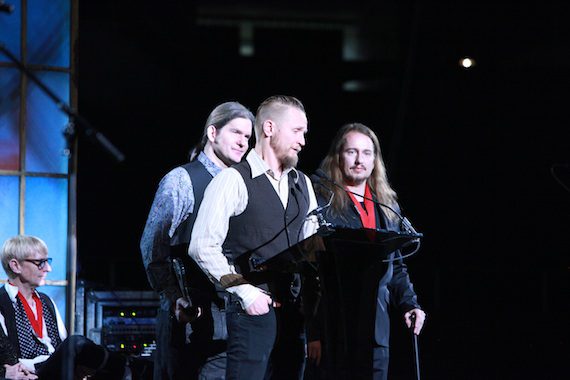 Sons of the late Roy Orbison, (left) Wesley Orbison (back), Alex Orbison (at mic) and Roy Kelton Orbison Jr. (far right) speaking on behalf of their father for his induction into the Musicians Hall of Fame in the Iconic Riff category for his legendary hit song “Oh, Pretty Woman” on the stage of Nashville’s Historic Municipal Auditorium on January 28th 