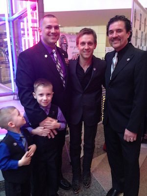 Pictured: Justin Moore and Scott Borchetta pose with “Your Heroes Name Here” honoree Samuel Deeds and his two sons.