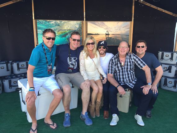 Chris Janson, winner of Country Song of the Year at the iHeartRadio Music Awards, posed for photos backstage at the ACM Party For a Cause Festival with TK Kimbrell (TKO Management), Peter Strickland (EVP & GM, WMN), Kelly Janson, John Esposito (President & CEO, WMN), and Storme Warren. 